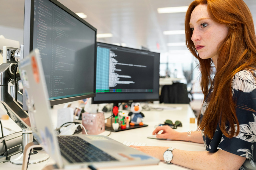 Software engineer writing backend code on computer in modern office
